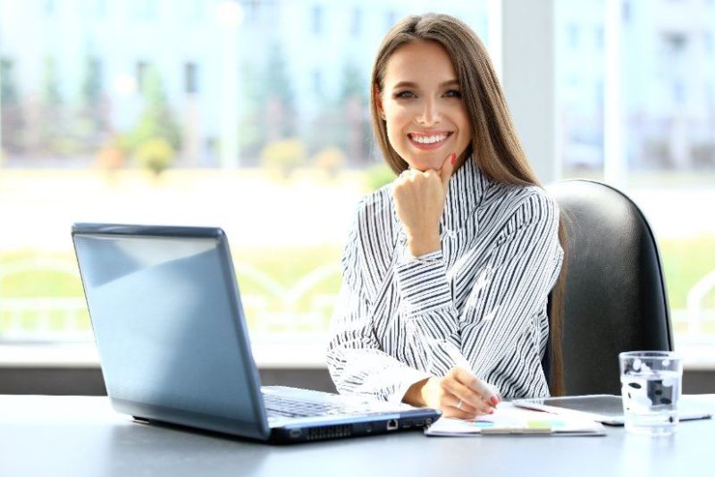 Frau am Laptop an einem hellen Büroarbeitsplatz